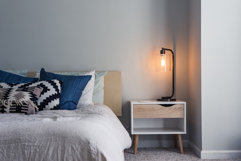 A serene Japandi room with low natural-wood furniture, soft neutral textiles, and a single ceramic vase