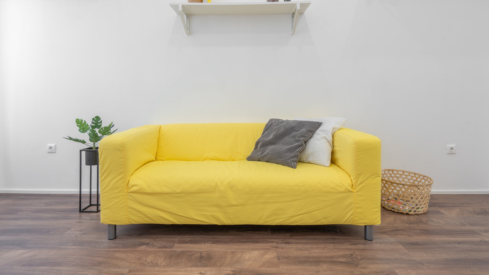 A compact entryway with wall hooks, a slim console, a small mirror, and a basket for shoes near the front door