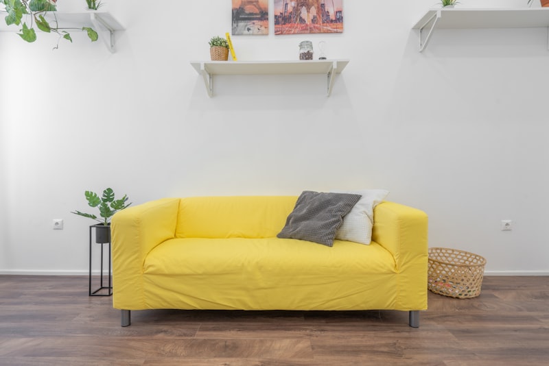 A serene minimalist room with a low neutral sofa, blank wall space, and a single sculptural floor lamp